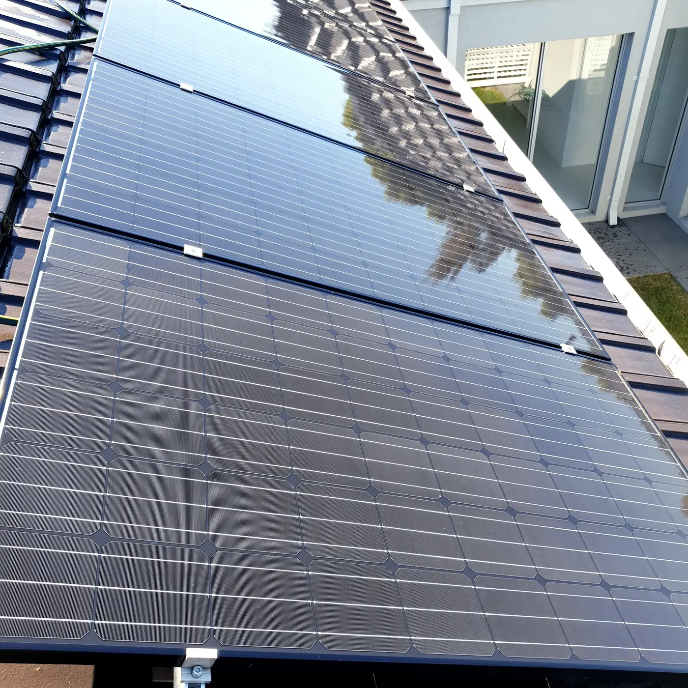 A dusty solar panel beside a freshly cleaned panel showing the difference a clean makes