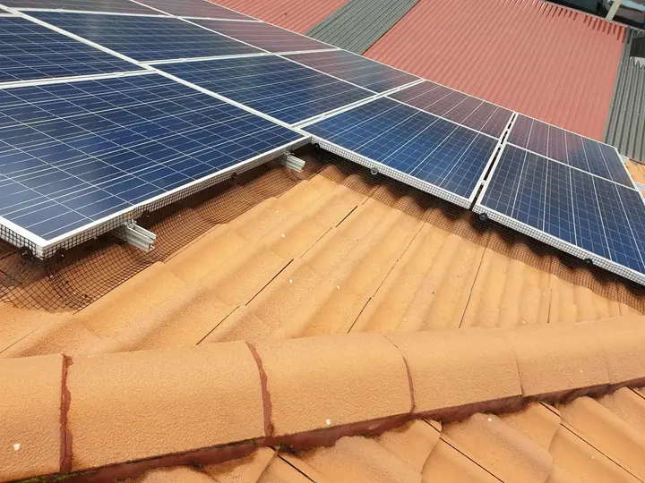 Bird proofing mesh fitted around solar panels on a tiled roof